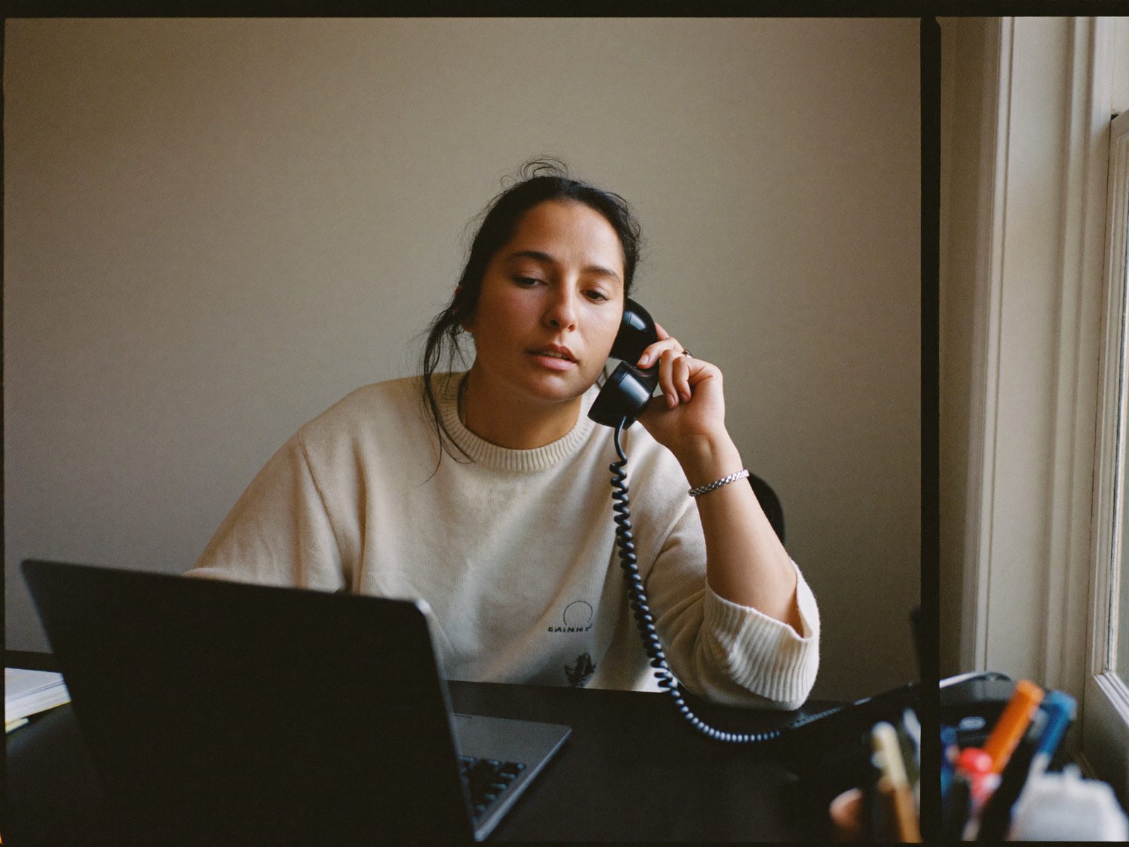 A local business owner answering a customer call at her desk